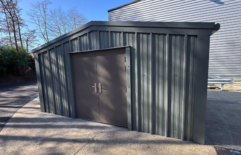 Small dark grey steel storage unit featuring large double doors on the front.